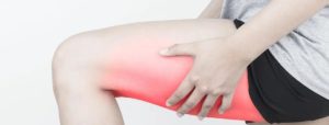 Persona che si tiene la parte anteriore della coscia destra con area evidenziata in rosso per dolore o infiammazione.