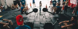 Persone durante una sessione di fitness in palestra con vogatori e altri esercizi, ambiente sportivo e dinamico