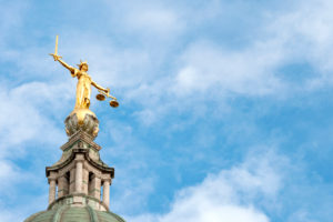 Statua dorata della Giustizia con spada e bilancia sulla cupola dell’Old Bailey a Londra.