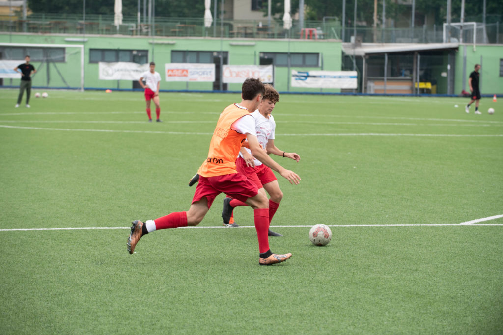 Calciatore in sprint durante una seduta ad alta intensità, simbolo della perturbazione biomeccanica generata dallo shock tattico post cambio allenatore
